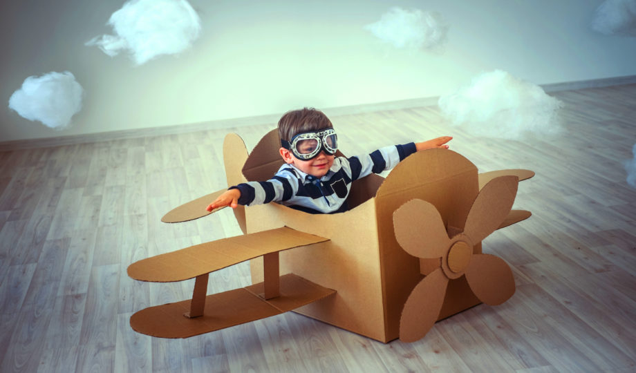 Criança voando em caixa de papelão